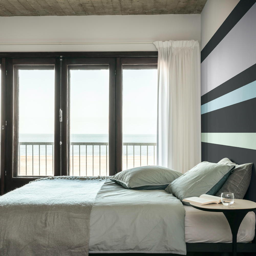 اتاق خواب با تخت خواب سفید و پنجره چوبی و پرده